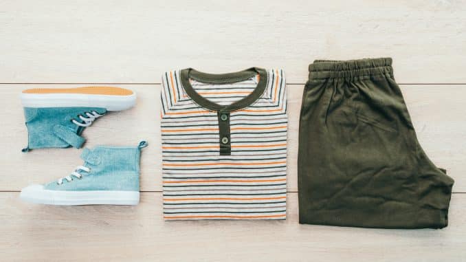 T-shirt with pants and shoes on wooden background