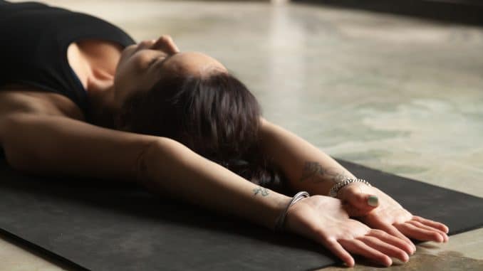 Young attractive woman stretching on the floor